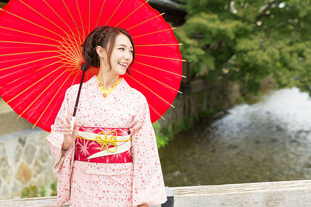 istock Woman wearing a kimono with a red umbrella 620378218