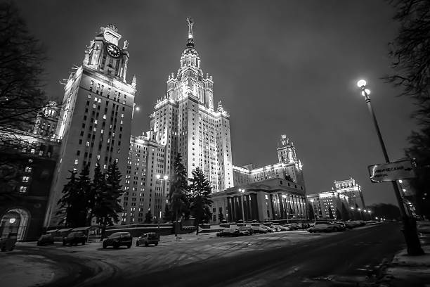Blurred black and white background from night wide angle picture of illuminated Moscow State University in winter
