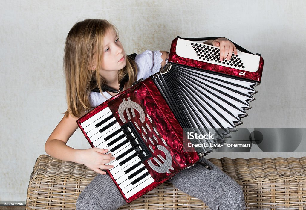 Girl playing an Accordion Girl concentration on playing an Accordion Accordion - Instrument Stock Photo