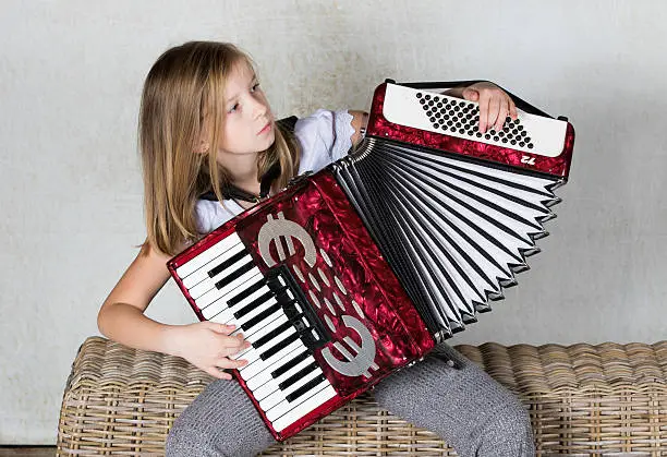 Girl concentration on playing an Accordion