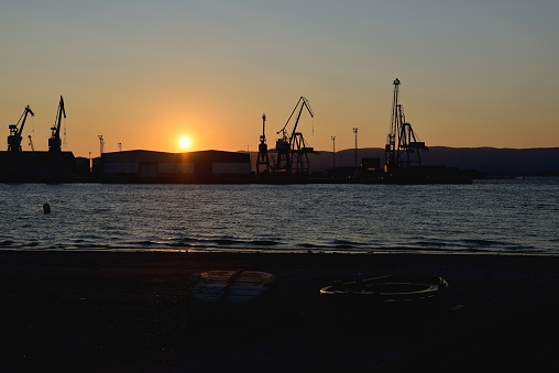 image of industrial repositories for oil and gas in the harbor at sunset