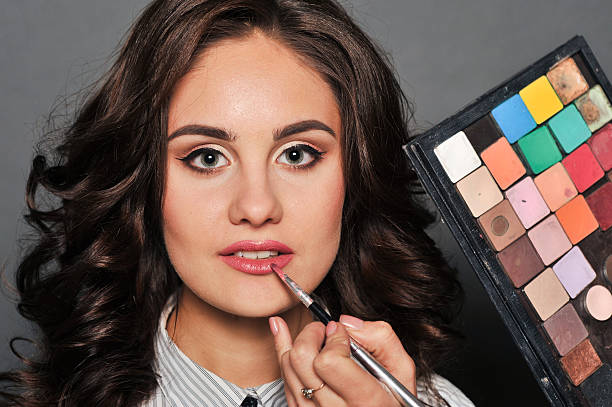 istock makeup artist paints a very pretty brunette 620381904
