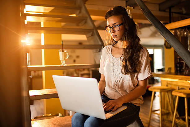 istock Young woman sitting on steps and working on laptop. 620381906