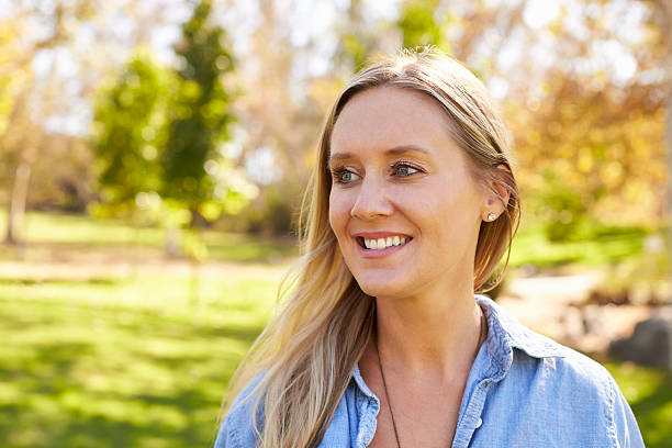 istock Mid thirties white woman looking away from camera in park 620382074