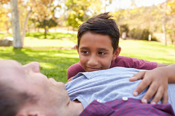 istock Mixed race boy lying in park with his white father 620382214