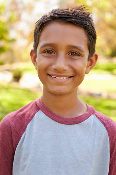istock Smiling mixed race boy in park looking to camera, vertical 620382236