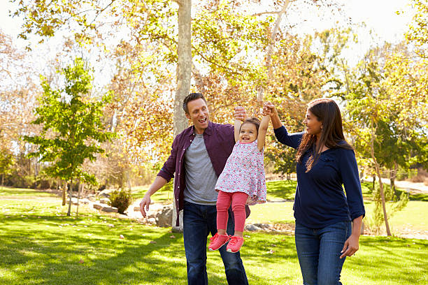 istock Mixed race couple lifting up their young daughter in park 620382242