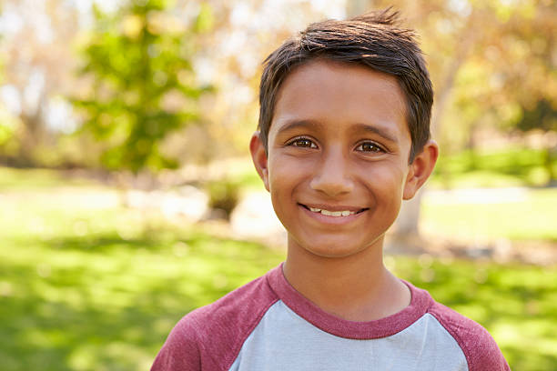 istock Mixed race Caucasian Asian boy in park looking to camera 620382284