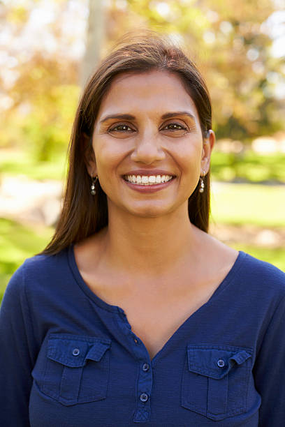 istock Smiling mixed race woman in park looking to camera, vertical 620382300