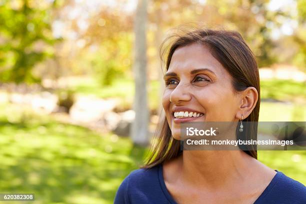 Smiling Mixed Race Woman In Park Looking Away From Camera Stock Photo - Download Image Now