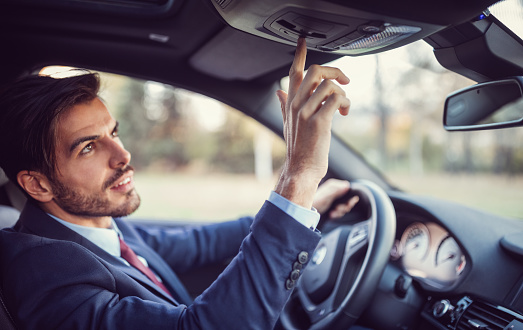 Businessman pressing the emergency button to contact the personal car assistant