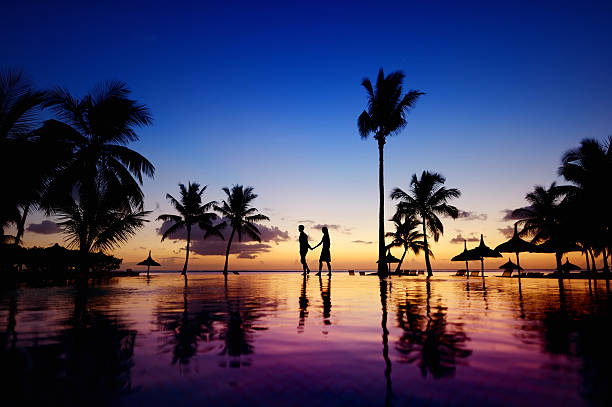 siluetas de pareja joven al atardecer escénico - honeymoon beach swimming pool couple fotografías e imágenes de stock