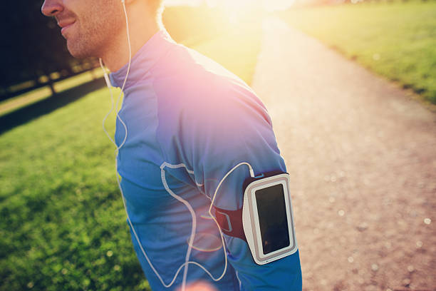 jovem atleta com braçadeira olhando para a frente no parque - set goals audio - fotografias e filmes do acervo