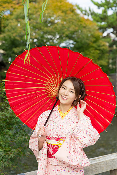 istock Woman wearing a kimono with a red umbrella 620383730