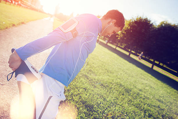 atleta com braçadeira fazendo exercícios no parque - set goals audio - fotografias e filmes do acervo