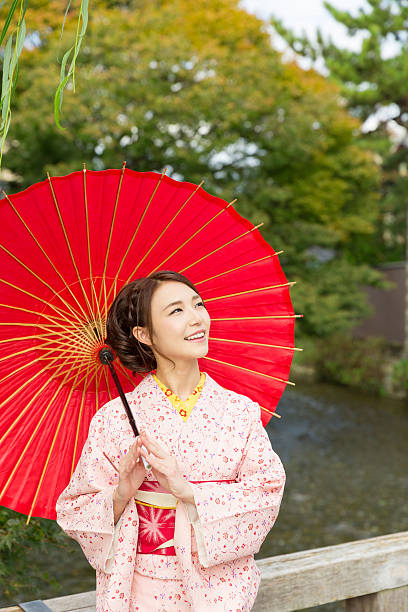 istock Woman wearing a kimono with a red umbrella 620383798