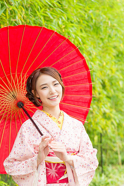 istock Woman wearing a kimono with a red umbrella 620384346