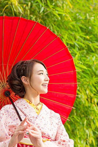 istock Woman wearing a kimono with a red umbrella 620384564