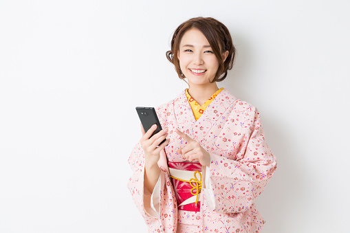 Woman wearing a kimono using a smartphone