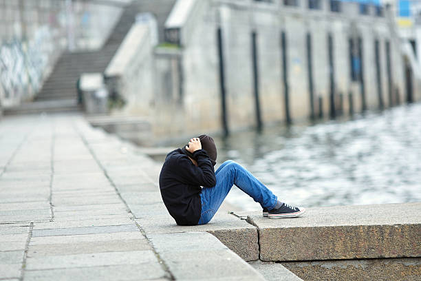 istock young homeless boy sleeping on the street 620389744