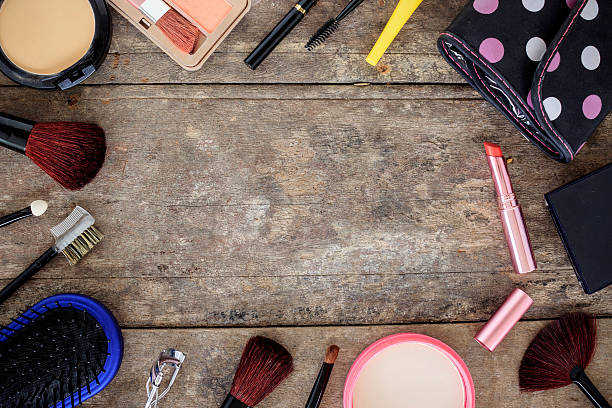 istock makeup cosmetics and brushes on wooden table background, over light 620391616