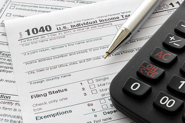 istock US tax form with pen and calculator, over light  [ 620393690