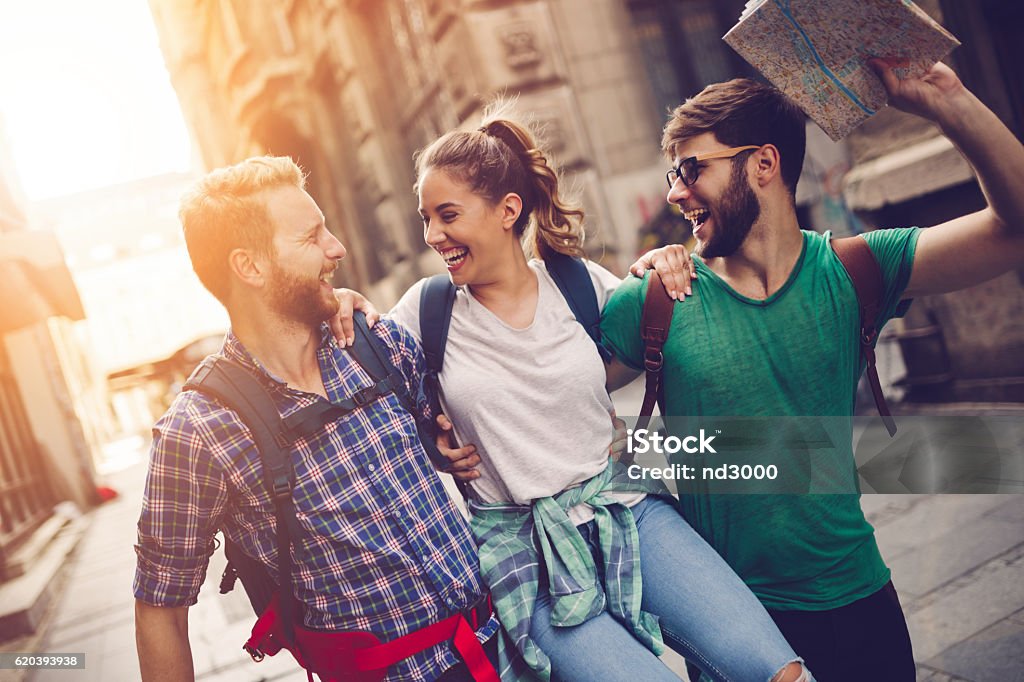 Happy traveling tourists sightseeing Happy traveling tourists sightseeing with map in hand Friendship Stock Photo