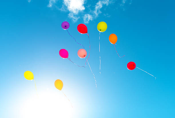 Many colorful baloons in the blue sky.
