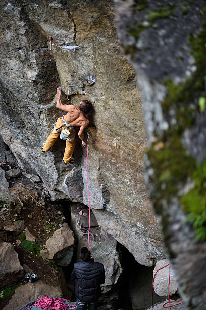 istock Young athletic male rock climber climbing cliff wall. 620395994