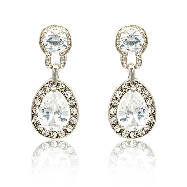 istock Pair of silver diamond earrings isolated on white 620397316