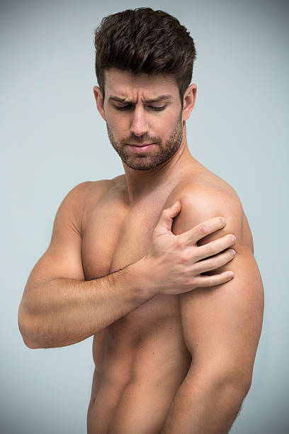 istock Guy holding his shoulder in pain 620398284