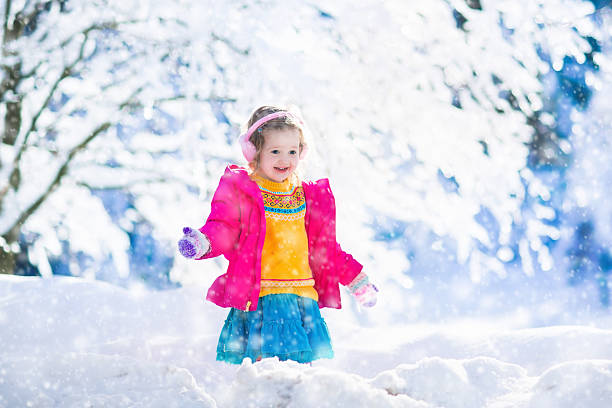 istock Child playing in snowy winter park 620399130