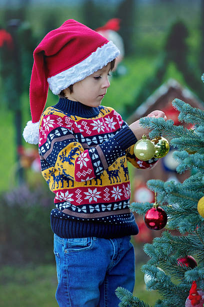 istock Cute little boy, decorating christmas tree, outdoor 620406138