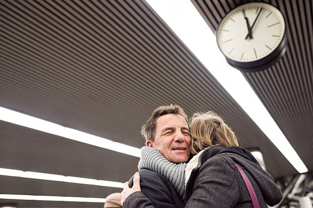 istock Senior couple standing at the underground platform, hugging 620406486