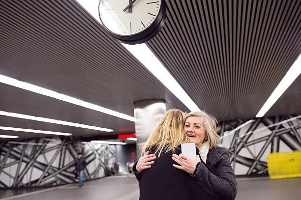 istock Two beautiful women standing at the underground platform, huggin 620406616