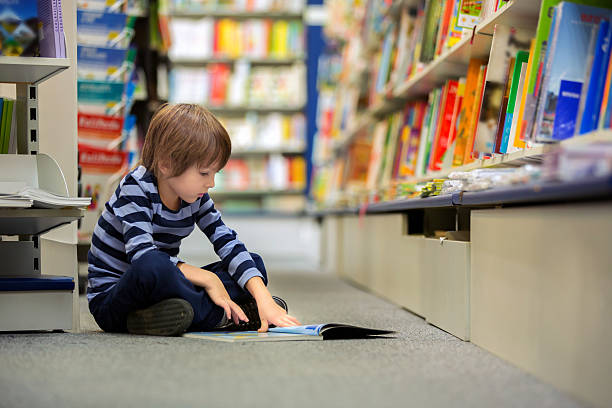 istock Adorable little child, boy, sitting in a book store 620407362