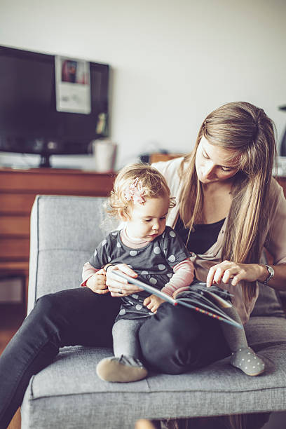 madre y su pequeña hija en casa - living room elegance women long hair fotografías e imágenes de stock