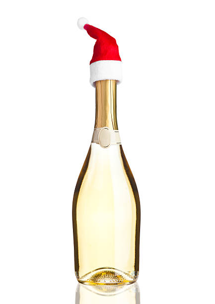 istock Bottle of yellow champagne with santa hat white 620408276