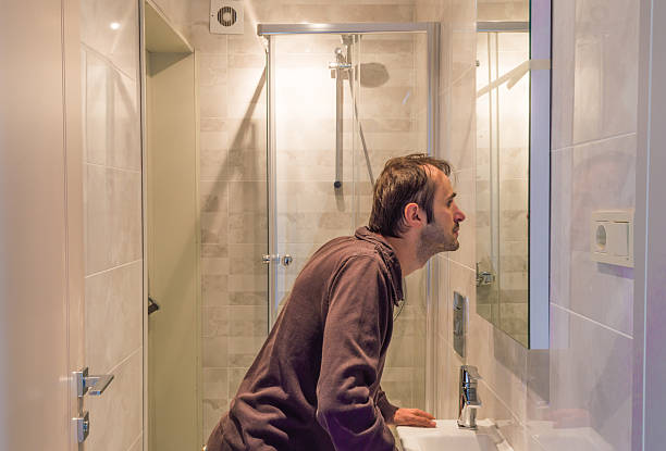 istock Man looking at himself in the mirror in a bathroom 620408478