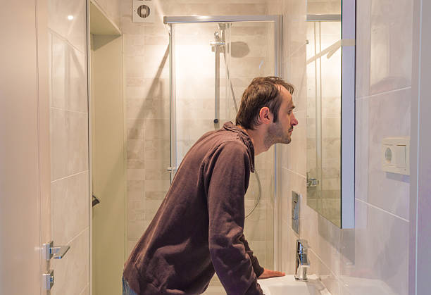 istock Man looking at himself in the mirror in a bathroom 620408504