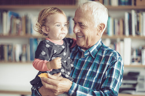 Candid portrait of a happy grandfather and his cute granddaughter.
