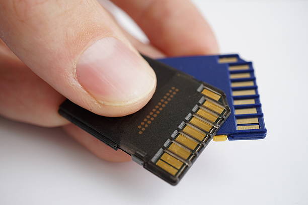 istock Male hand holding isolated plastic compact memory cards 620410800