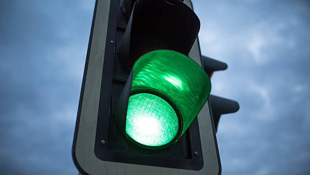 Green wave Traffic light in green at dusk green light stoplight photos stock pictures, royalty-free photos & images