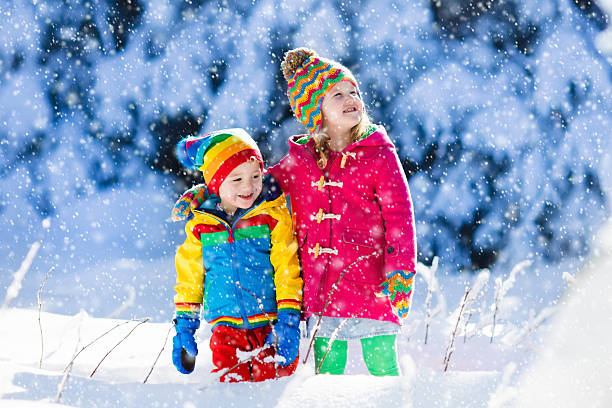 istock Children in colorful jacket playing in snowy winter forest 620702358