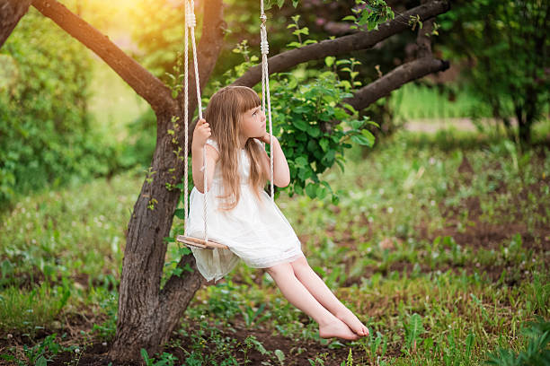 istock Little girl sitting on a swing 620703278