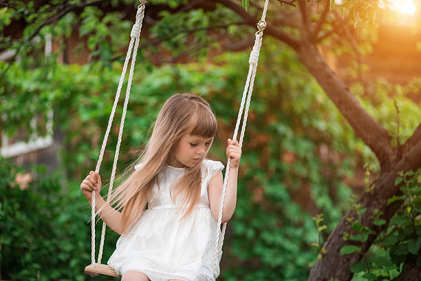 istock Little girl sitting on a swing 620703722