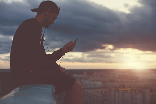 istock Brave man sitting on the edge of the roof 620704792