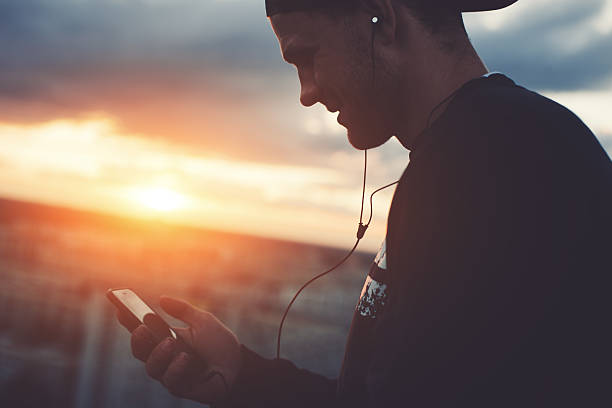 istock Smiling man with smartphone listening music 620705314