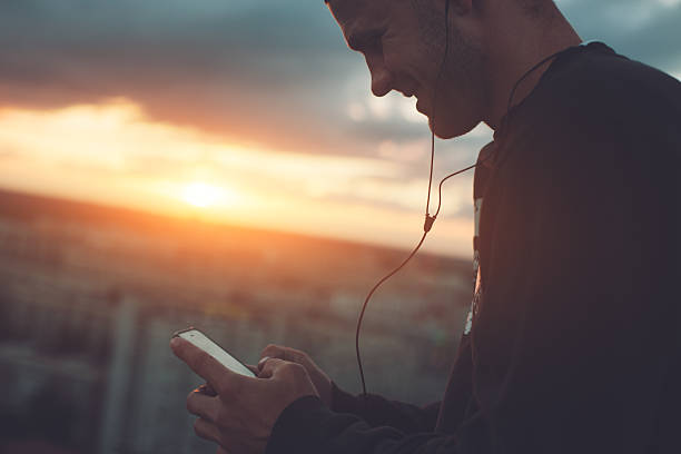 istock Smiling man listening music on roof 620705528