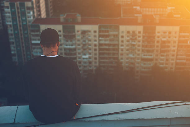 istock Brave man sitting on the edge of the roof 620705578